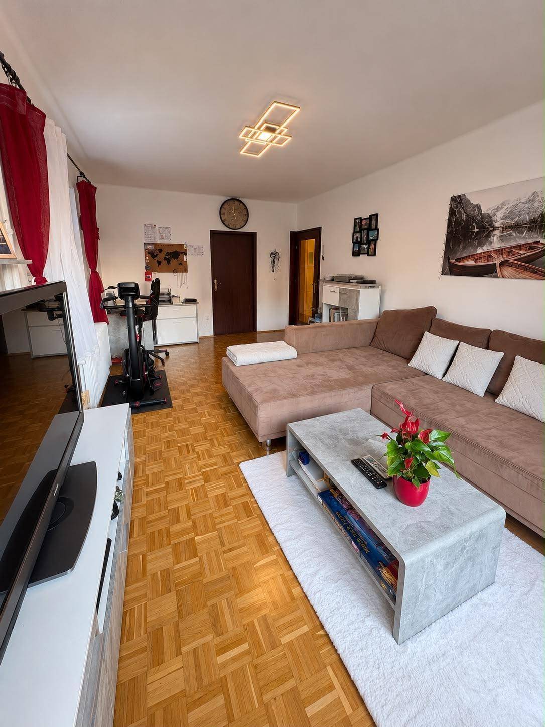 Geräumiges Wohnzimmer mit großem Sofa, Couchtisch und Parkettboden.
