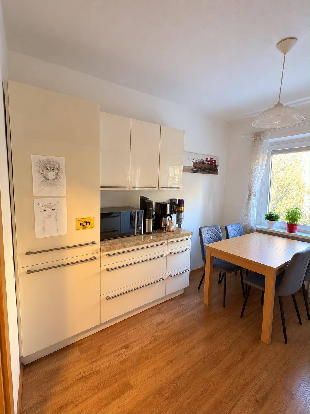 Moderne Küche mit integrierten Geräten, Essbereich und viel Stauraum.