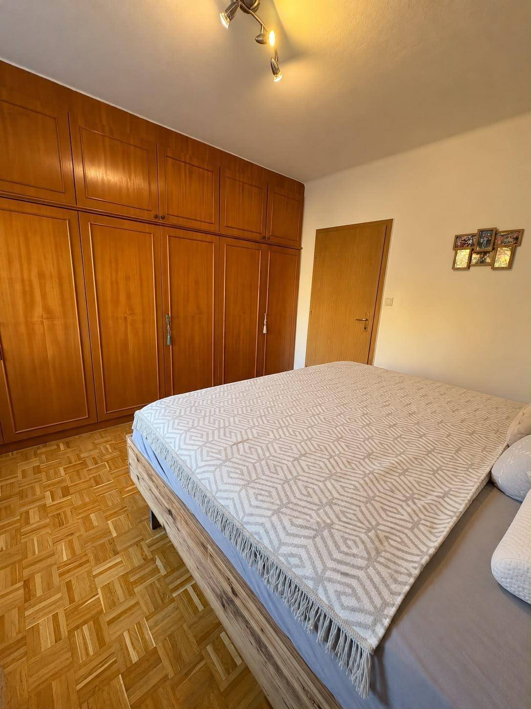 Schlafzimmer mit großem Doppelbett und geräumigen Einbauschränken aus Holz.