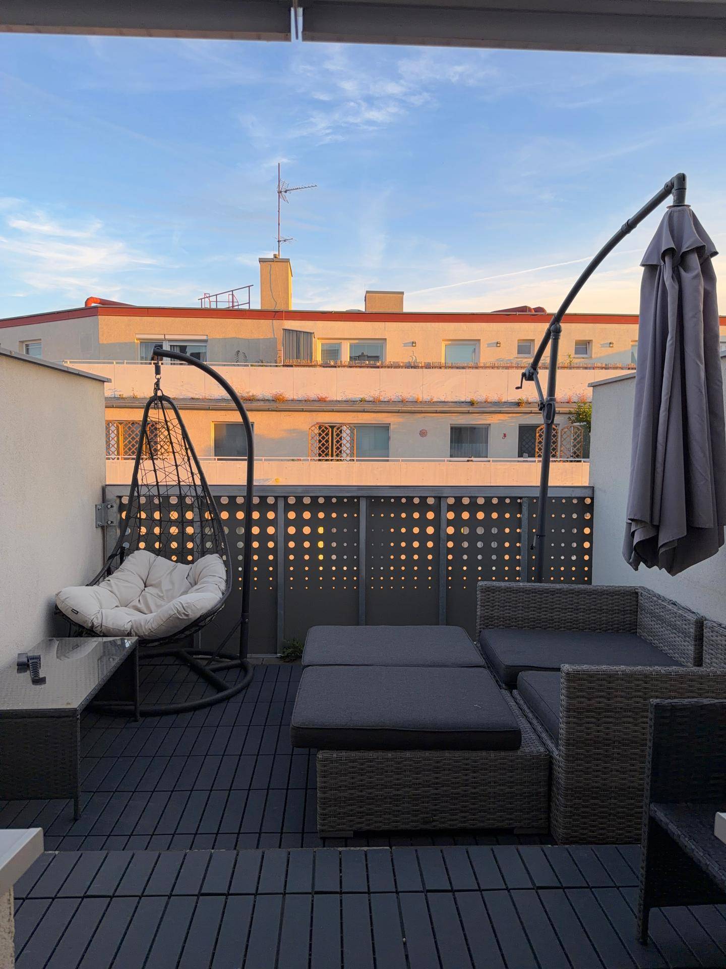 Geräumige Dachterrasse mit bequemen Loungemöbeln und Blick auf die umliegenden Gebäude.