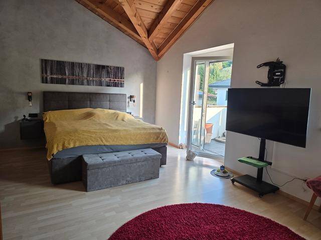 Geräumiges Schlafzimmer mit Doppelbett, Stauraum und Zugang zu einem Außenbereich.
