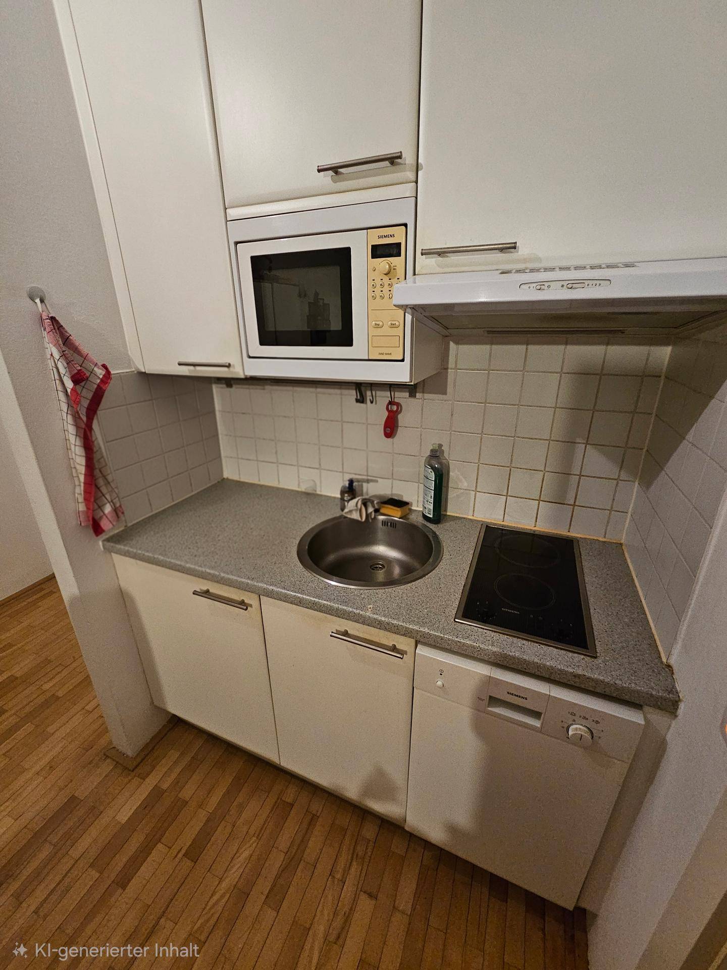 Kompakte Küchenzeile mit Spüle, Kochfeld, Mikrowelle und integriertem Geschirrspüler.