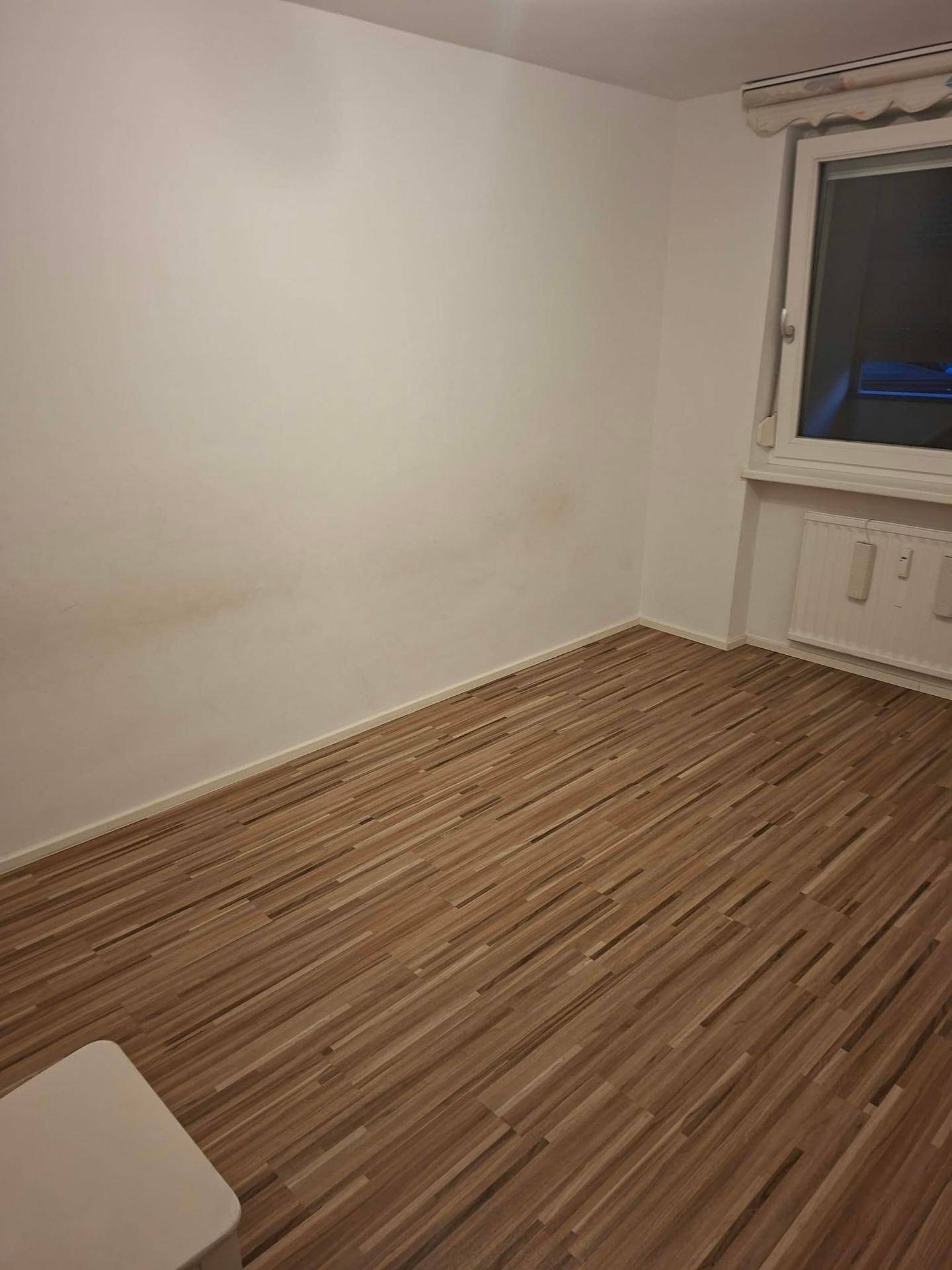 Helles Zimmer mit Laminatboden und Fenster, ideal als Schlaf- oder Arbeitszimmer nutzbar.