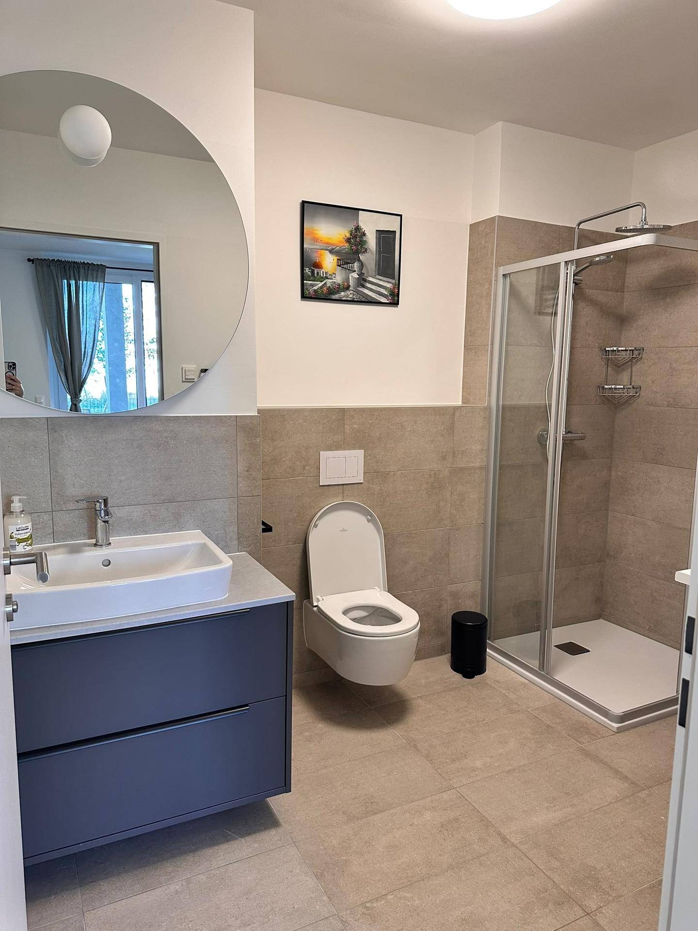 Modernes Badezimmer mit ebenerdiger Dusche, Hänge-WC und stilvollem Waschtisch.