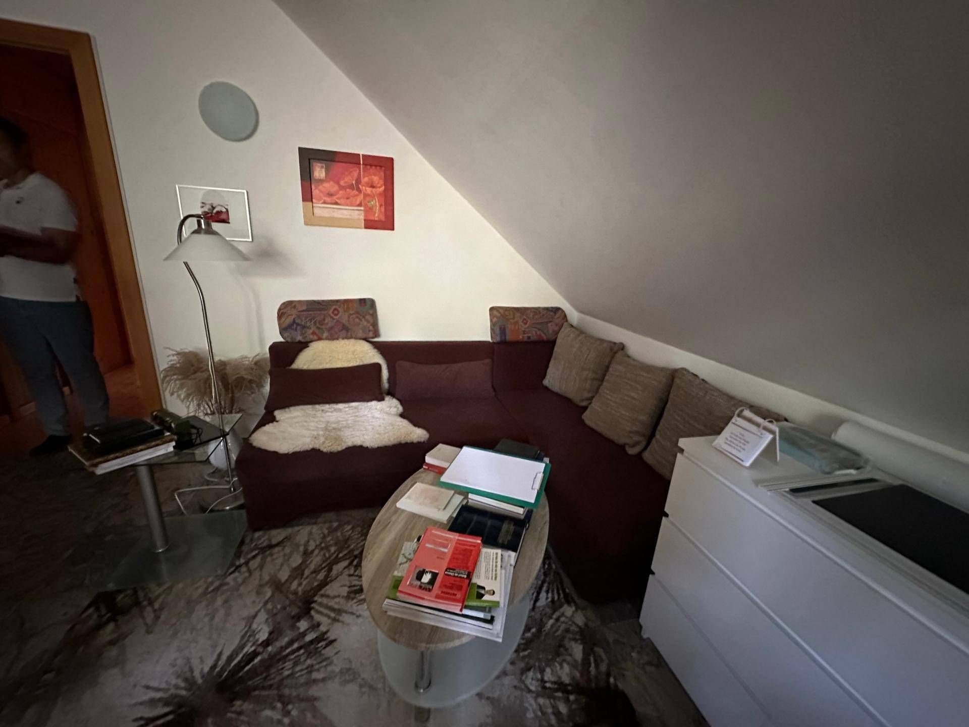 Gemütlicher Wohnbereich im Dachgeschoss mit Ecksofa, Couchtisch und Teppichboden.