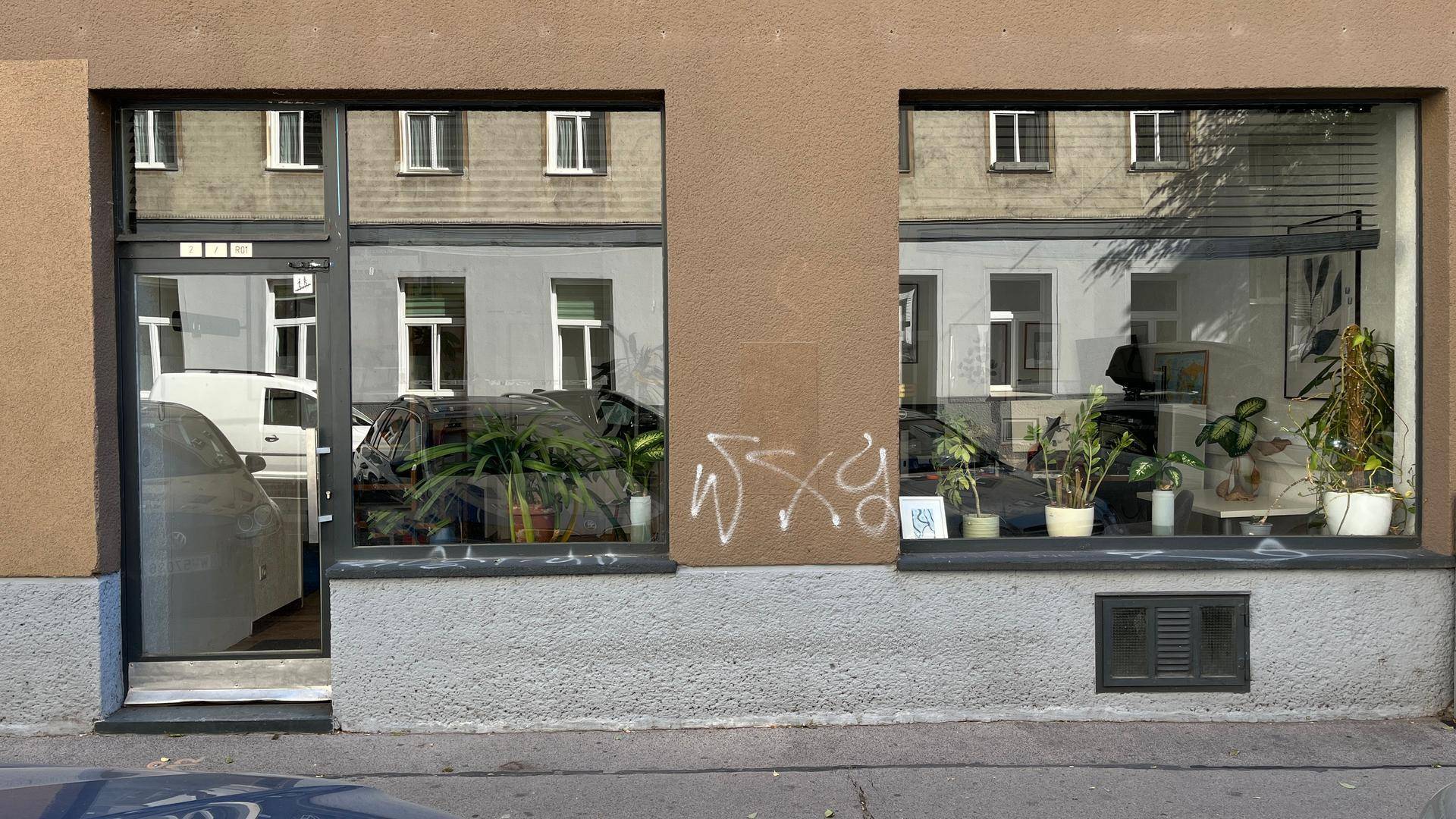 Fassade eines Geschäftsgebäudes mit großen Schaufenstern und reflektierenden Oberflächen.