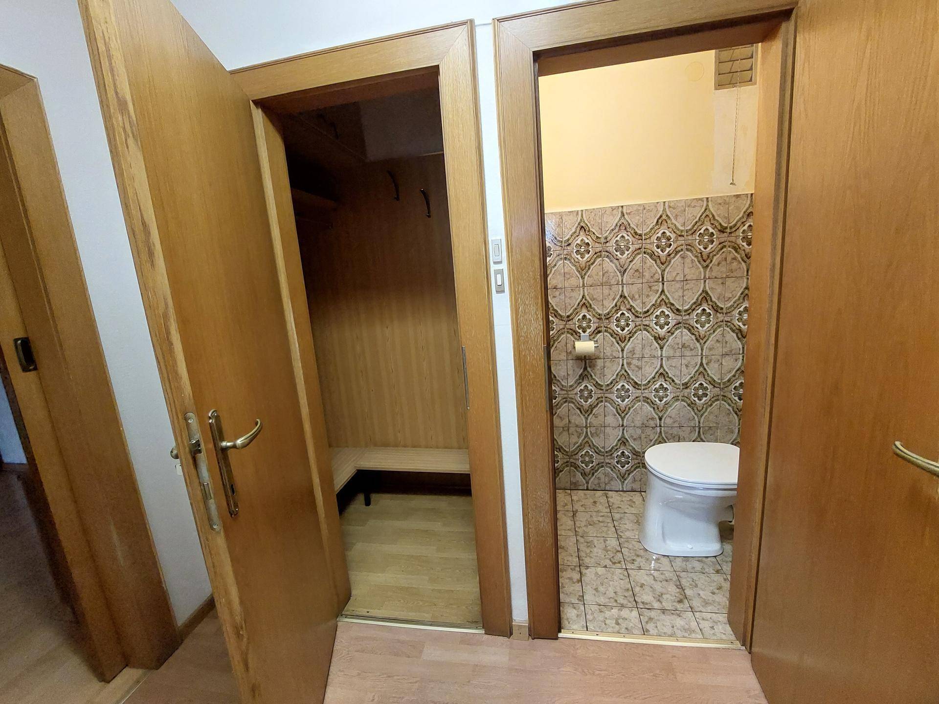 Flur mit Zugang zu einem Gäste-WC und einem kleinen Abstellraum.
