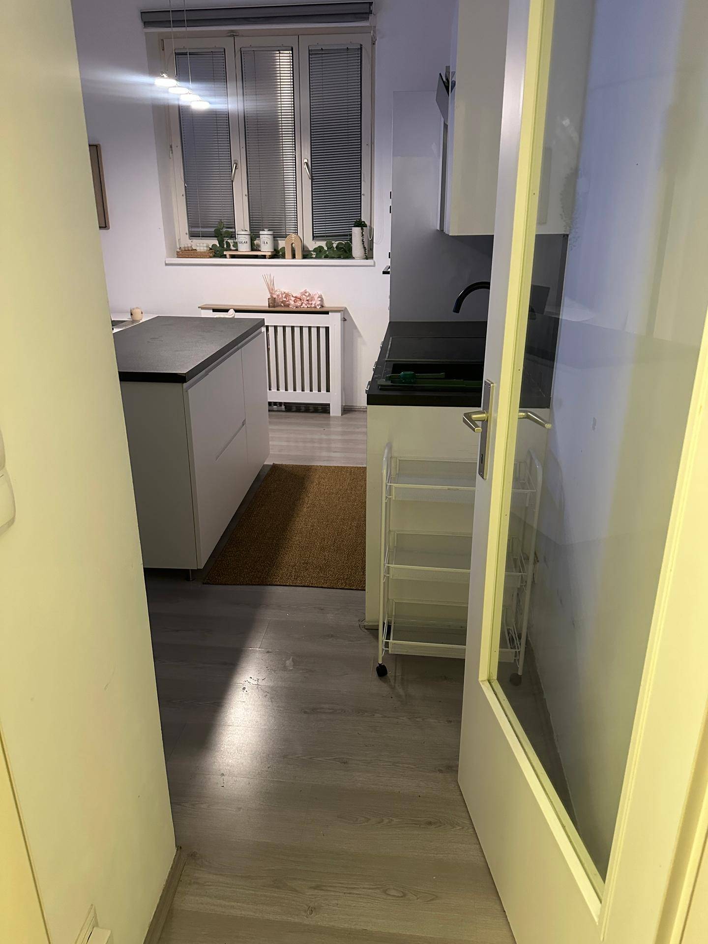 Blick in die moderne Küche mit Kücheninsel und Fenster, die einen hellen Kochbereich bietet.