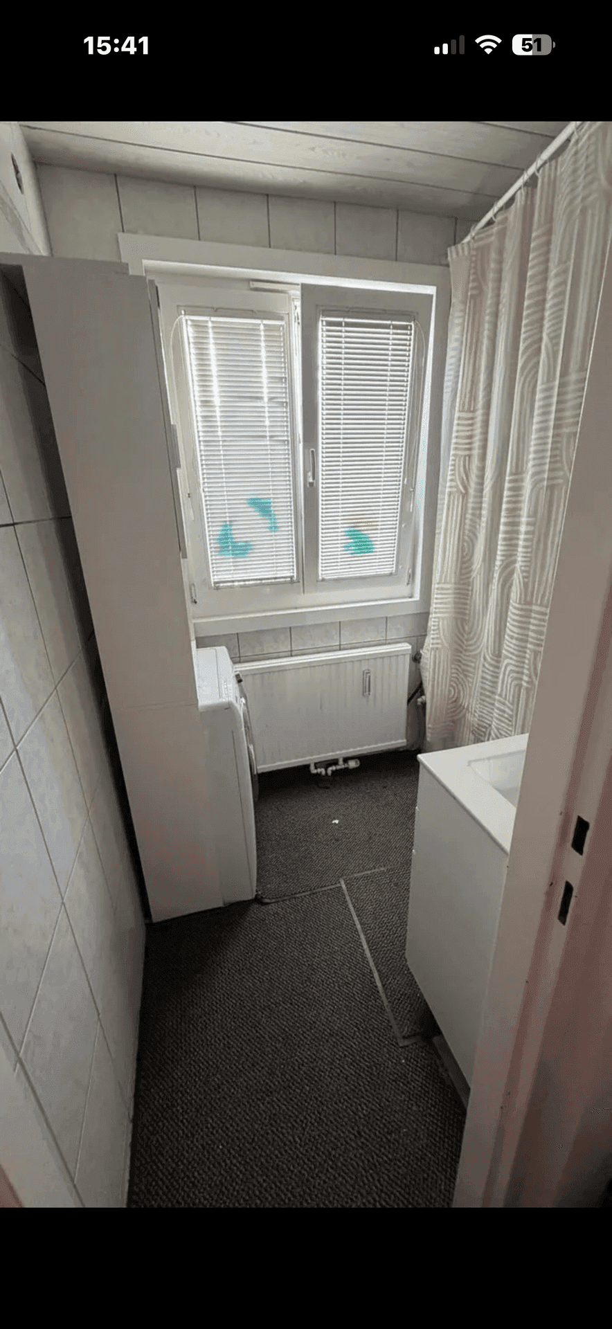 Kleiner Raum mit Fenster, Heizkörper und Platz für eine Waschmaschine, ideal als Hauswirtschaftsraum.