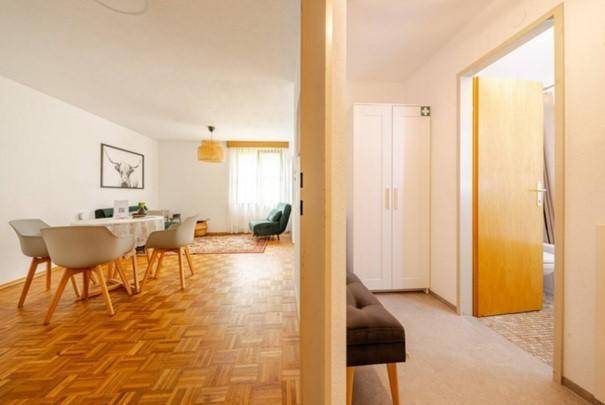 Flur mit Blick in den offenen Wohnbereich und Zugang zu einem weiteren Zimmer.