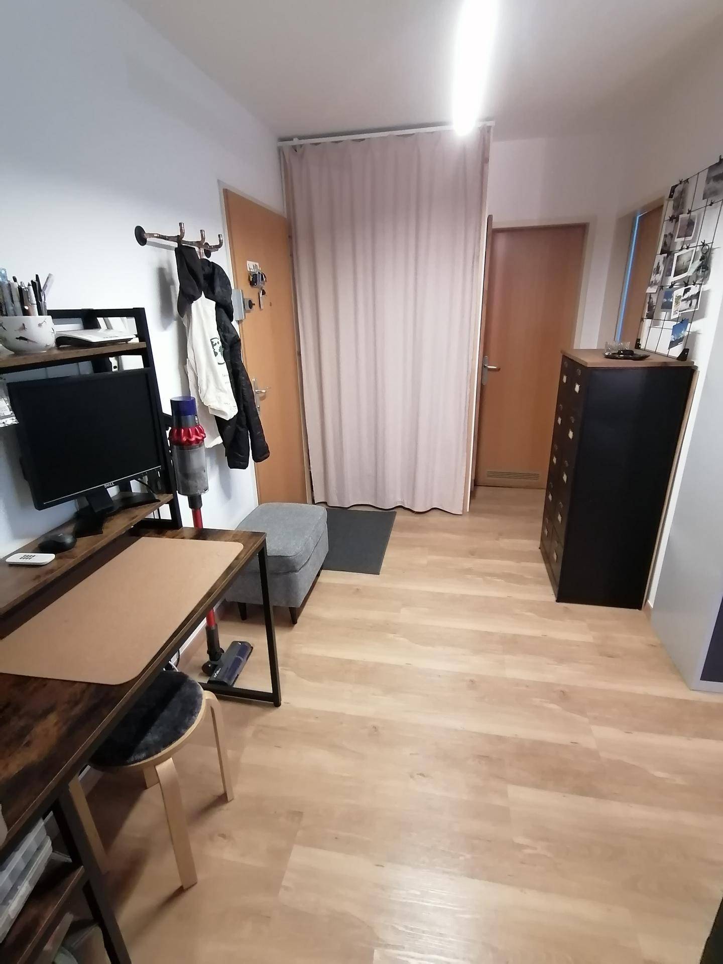 Langer Flur mit Laminatboden, Garderobe und Zugang zu weiteren Räumen.