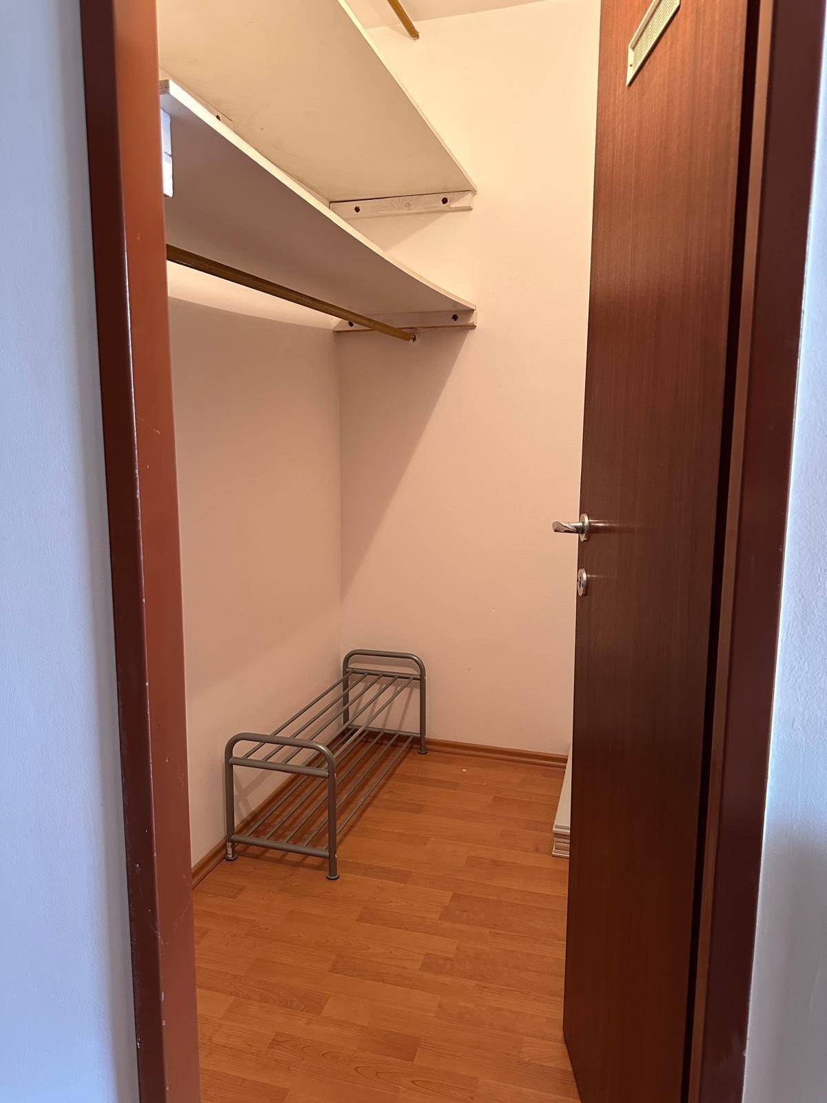 Praktischer Abstellraum mit Regalen und einem Schuhregal, ideal für zusätzlichen Stauraum.