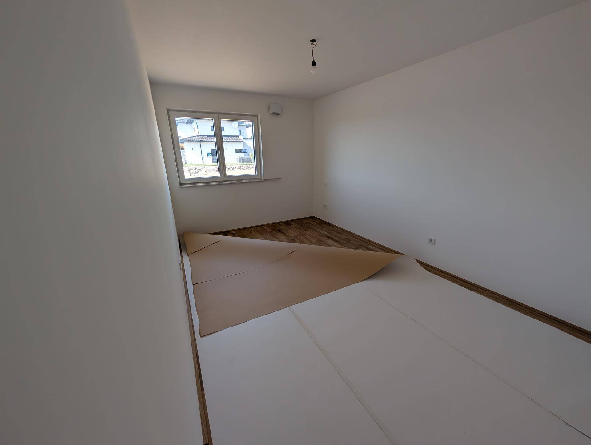 Schlafzimmer mit Parkettboden und Fenster, bereit für die individuelle Gestaltung.