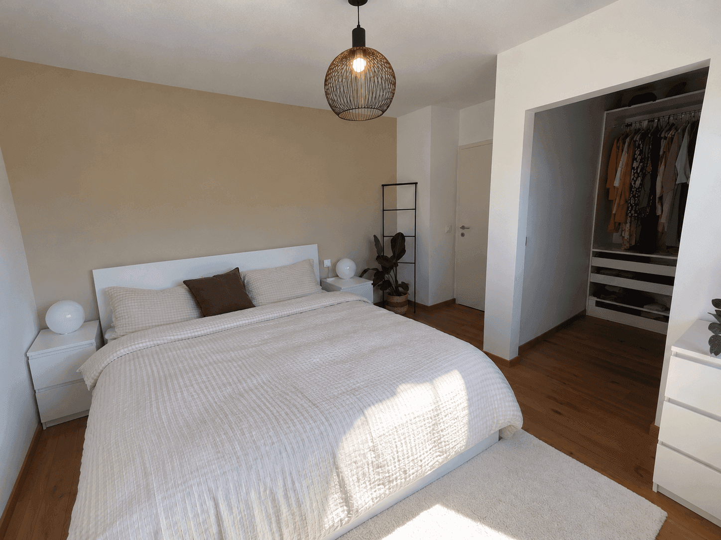 Geräumiges Schlafzimmer mit begehbarem Kleiderschrank und Holzboden.