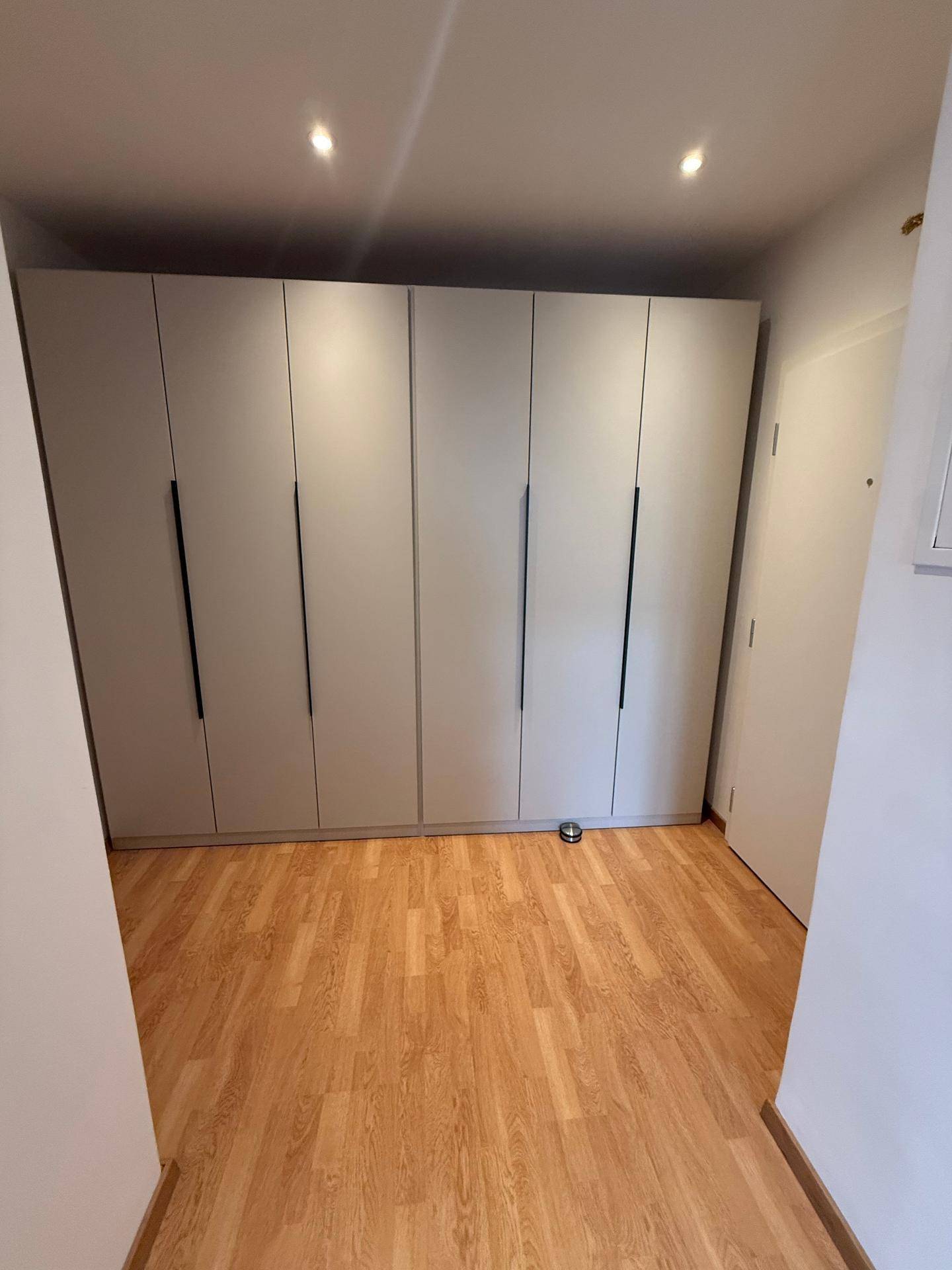 Geräumiger Flur mit modernen Einbauschränken und hellem Holzparkett.