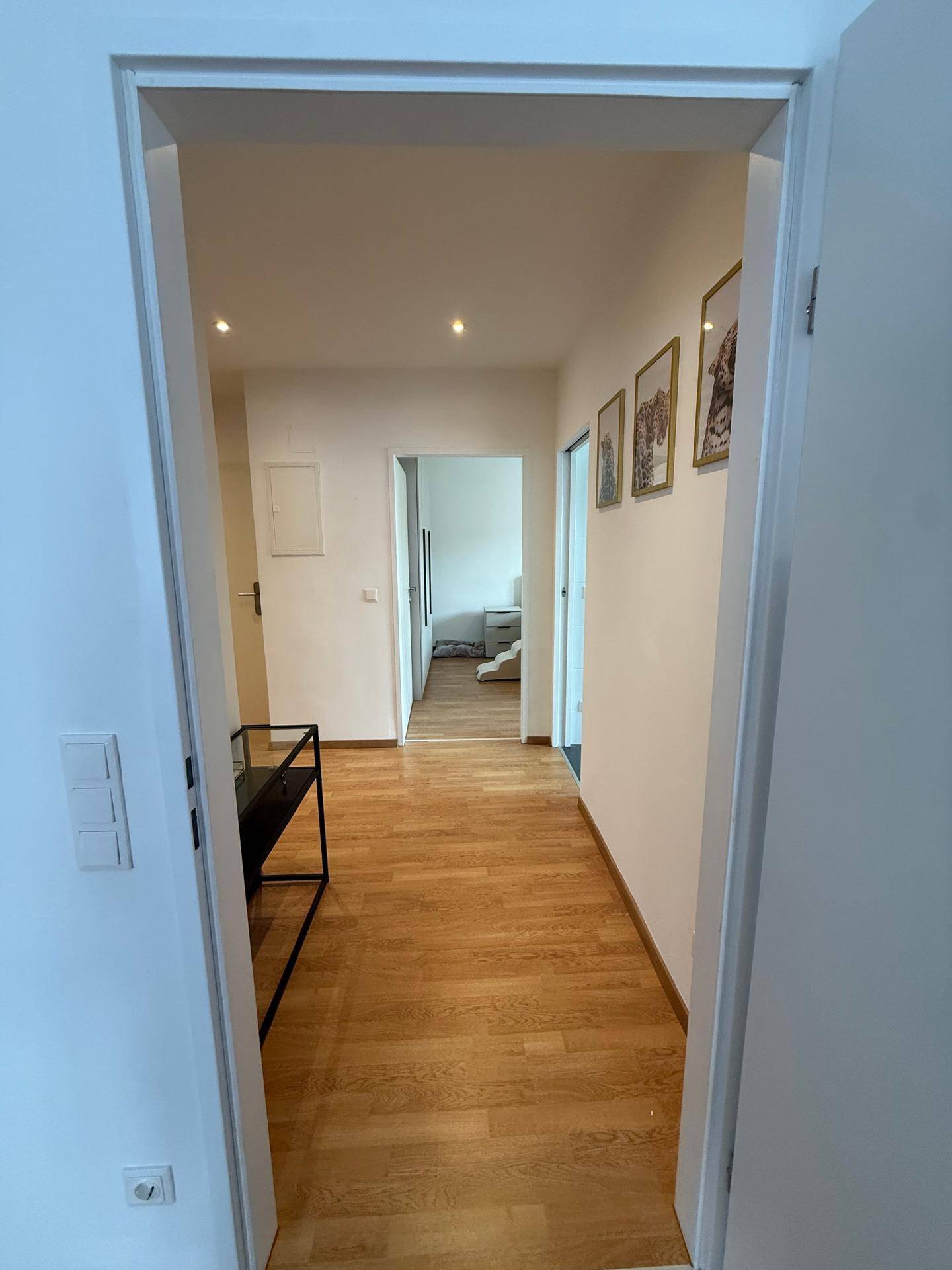 Langer, heller Flur mit Holzfußboden und Zugang zu verschiedenen Räumen.
