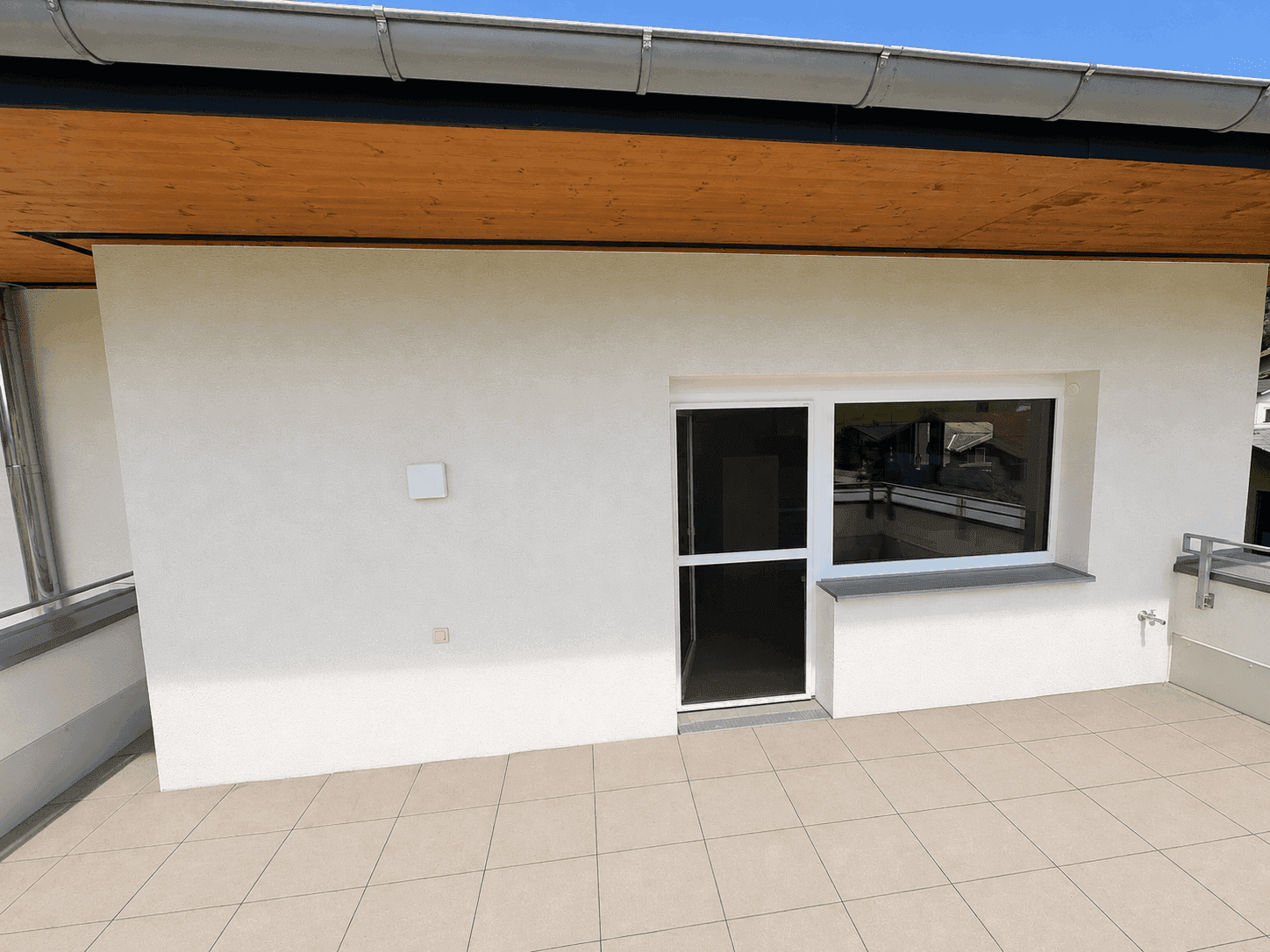 Zugang zur großen Terrasse von der Wohnung aus, mit Blick auf die Umgebung.