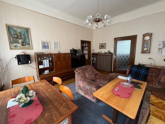 Blick auf den Essbereich und das Wohnzimmer mit Holzmöbeln und traditioneller Dekoration.