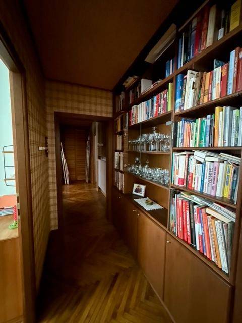 Flur mit Bücherregalen, die bis zur Decke reichen, und einem Fischgrätparkettboden.