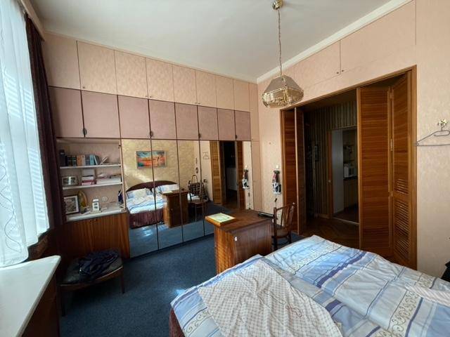Schlafzimmer mit Doppelbett, Spiegelschränken und einem Schreibtischbereich.