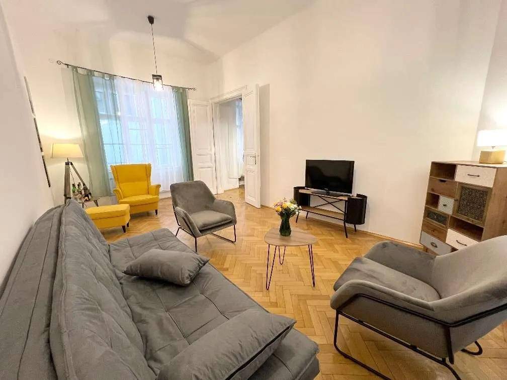 Geräumiges Wohnzimmer mit Fischgrätparkett, bequemen Sofas und einem dekorativen Beistelltisch in der Mitte.