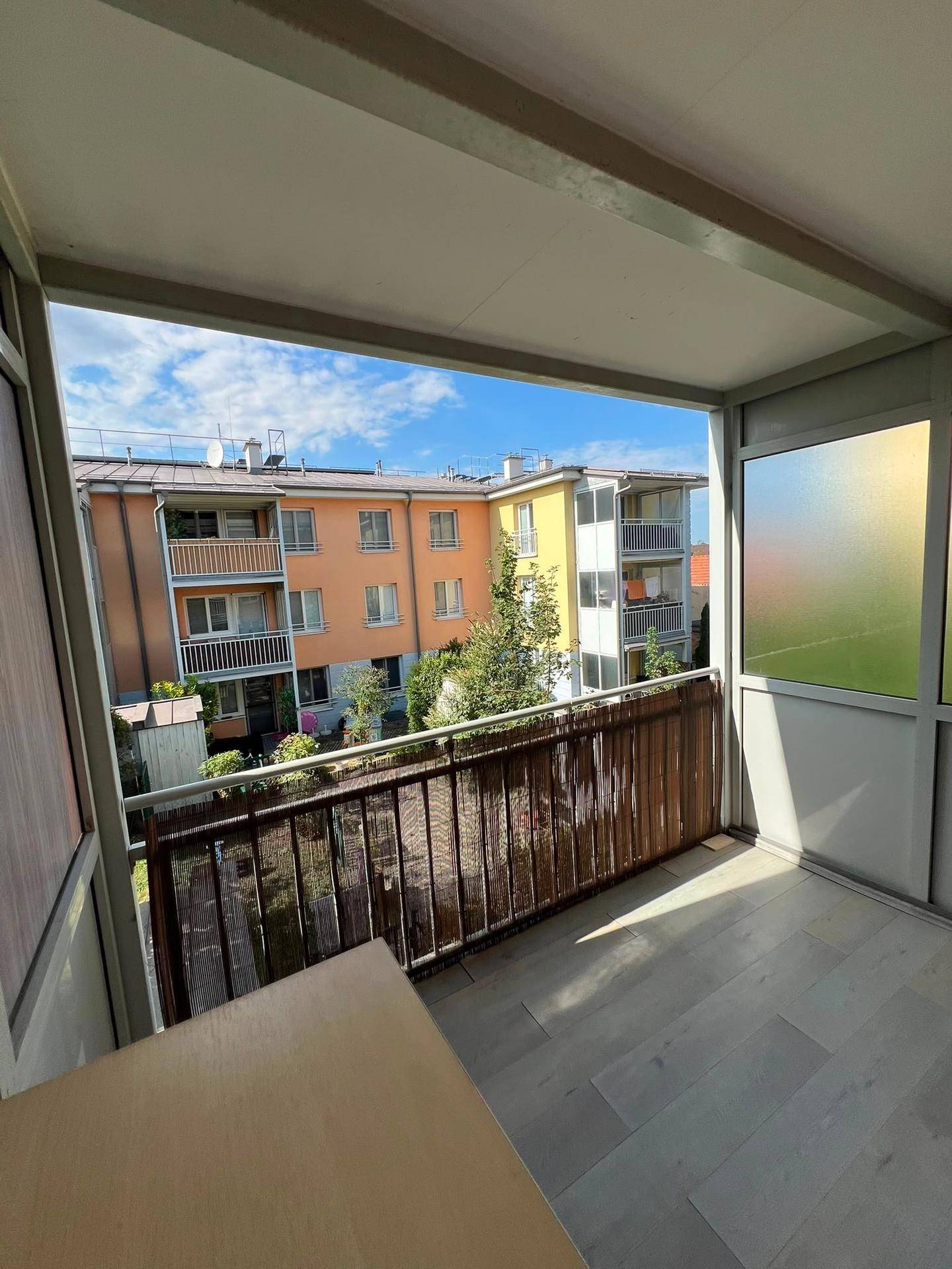 Überdachter Balkon mit Blick auf die umliegenden Wohngebäude und viel Tageslicht.