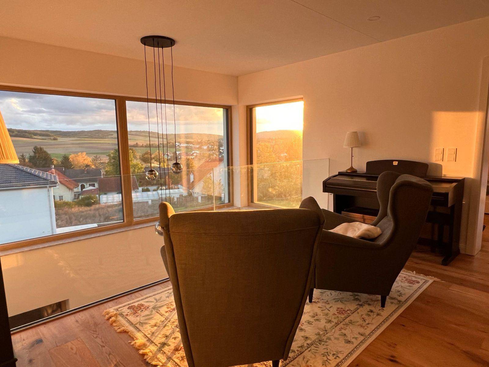 Heller Sitzbereich mit bequemen Sesseln und Panoramablick in die Landschaft.