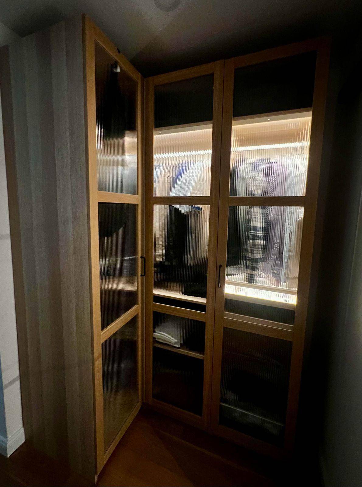 Beleuchteter Einbauschrank mit Glasfronten und viel Stauraum für Kleidung.
