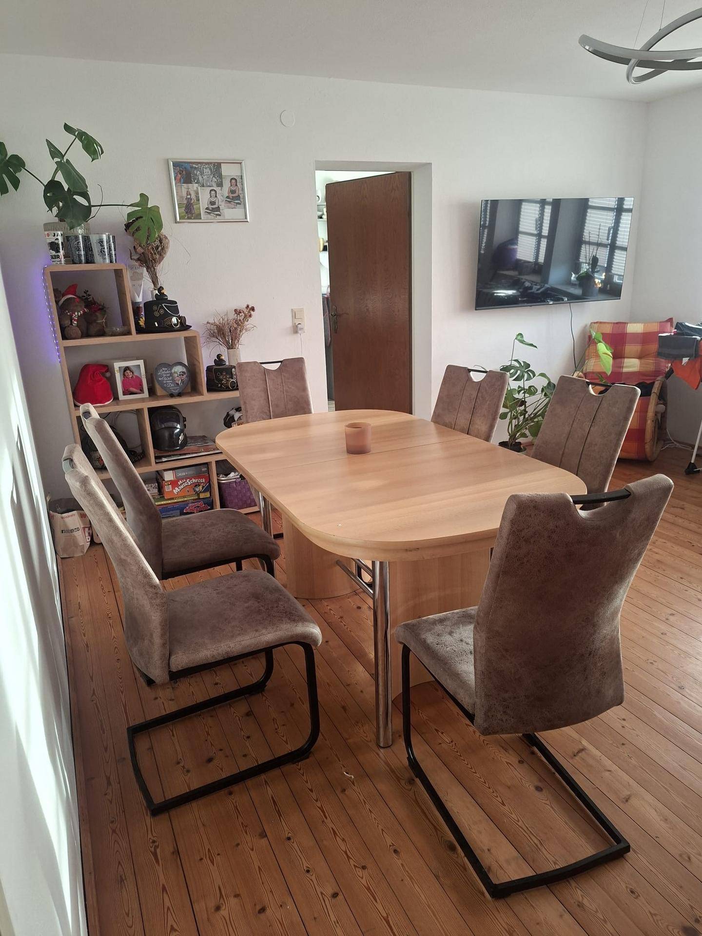 Gemütlicher Essbereich mit Holztisch und sechs Stühlen, ideal für gemeinsame Mahlzeiten.