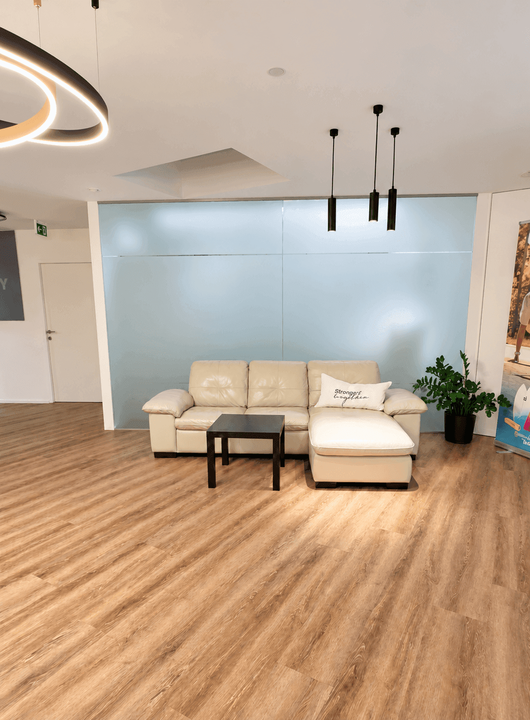 Heller Flurbereich mit beigem Ledersofa, kleinem Beistelltisch und Holzfußboden.