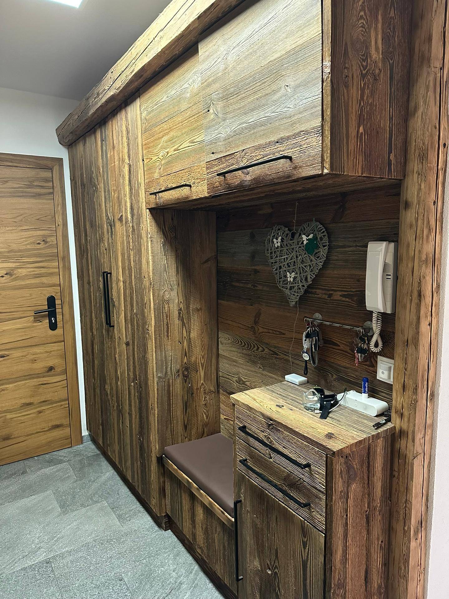 Rustikaler Eingangsbereich mit maßgefertigten Holzmöbeln und integrierter Sitzbank für Komfort.