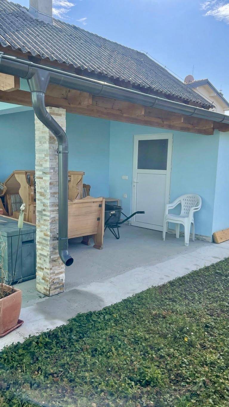 Überdachte Terrasse mit hellblauen Wänden und Holzbalken, ideal für entspannte Stunden im Freien.