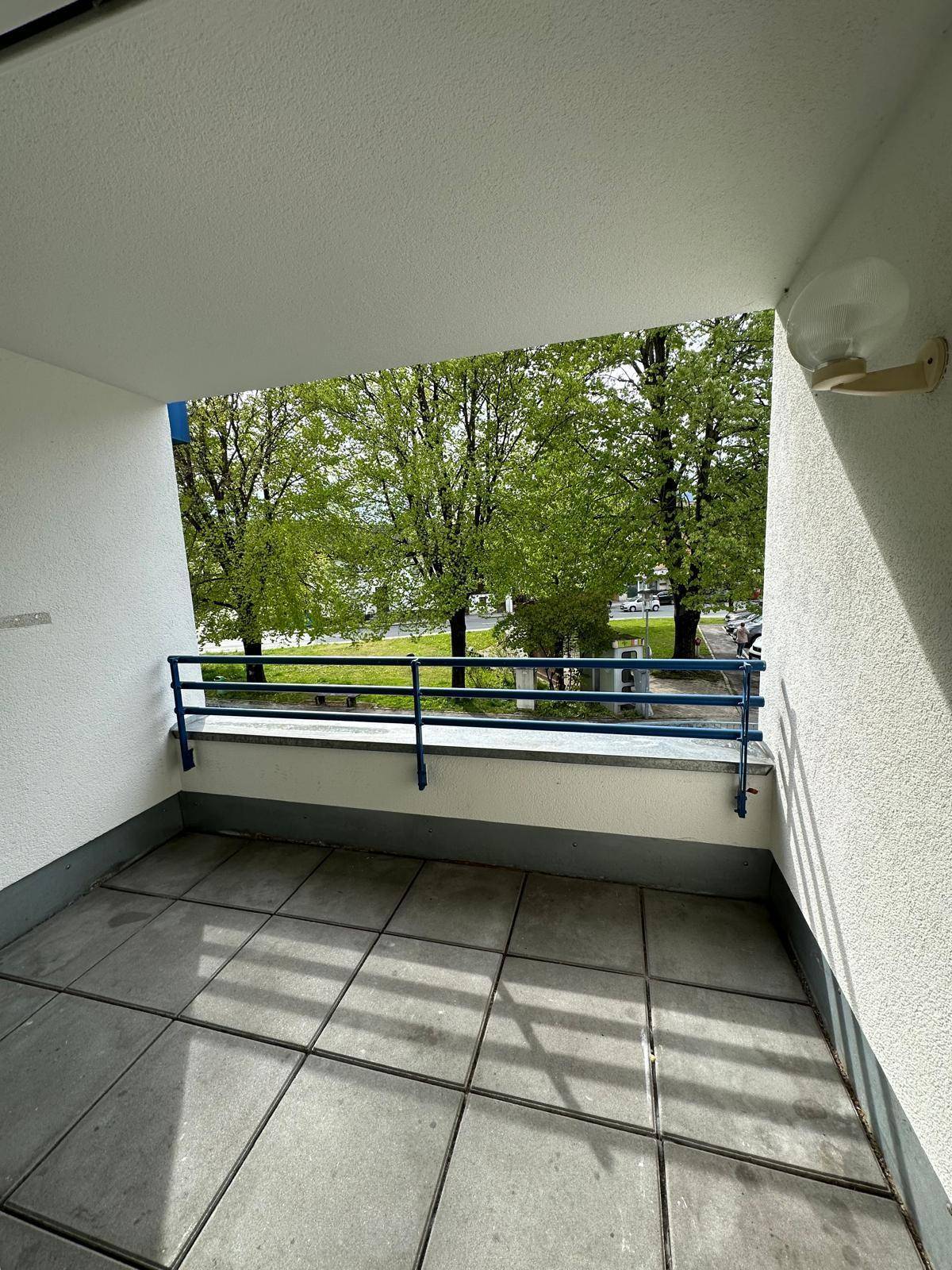 Geräumiger Balkon mit Fliesenboden und Blick ins Grüne, ideal für entspannte Stunden im Freien.