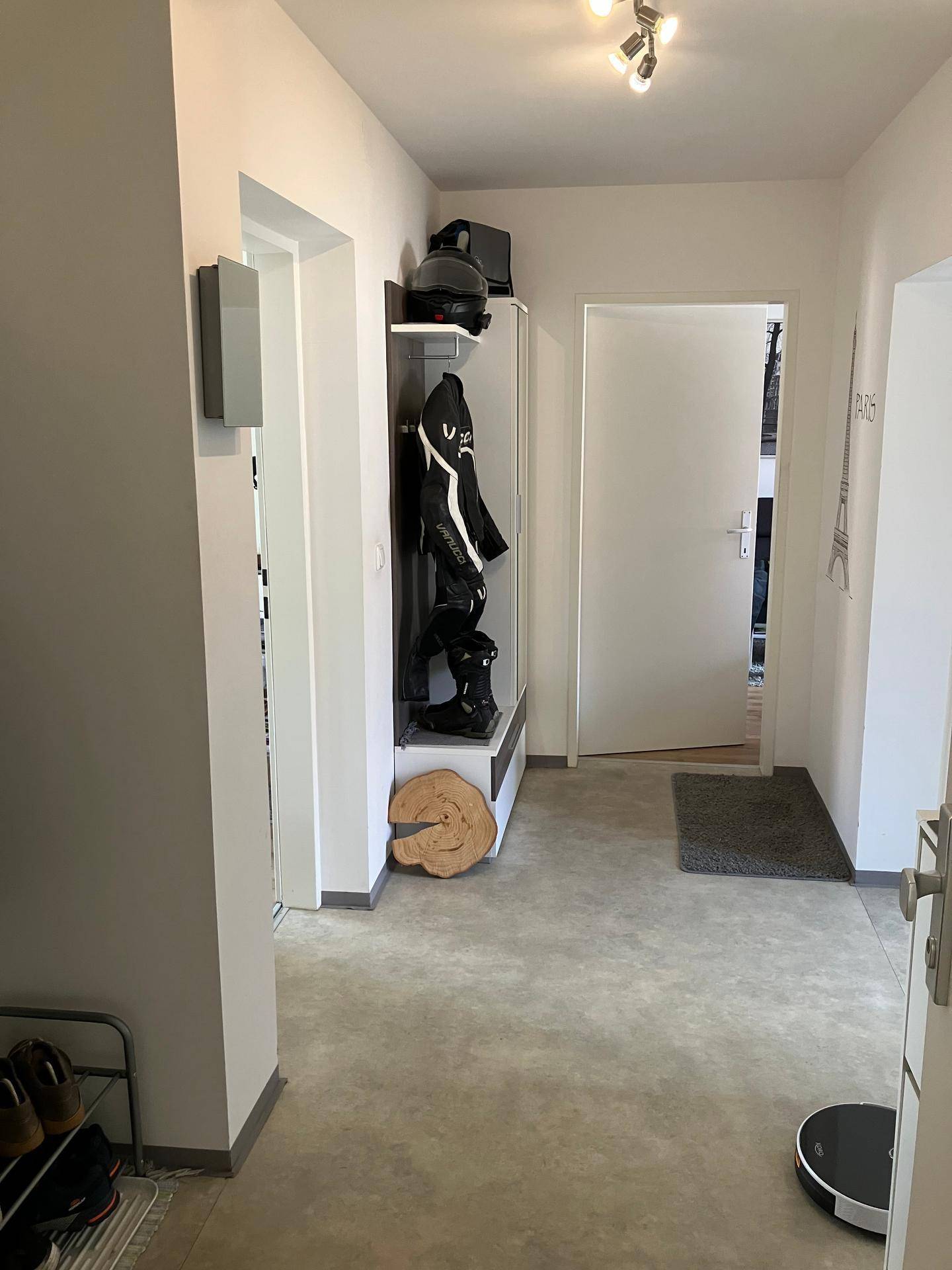 Heller Flur mit Garderobe und modernem Bodenbelag, der zu den weiteren Räumen führt.