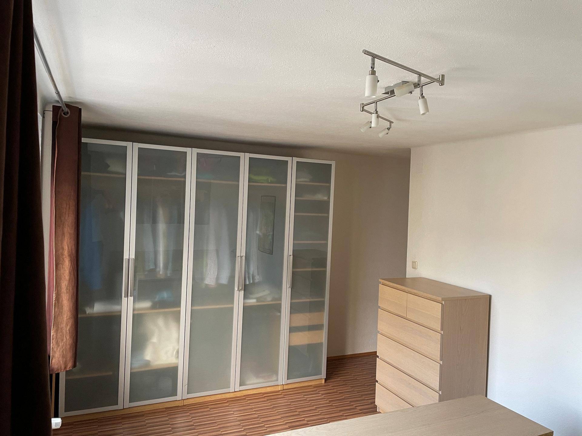 Schlafzimmer mit großem Kleiderschrank und Kommode, bietet viel Stauraum.