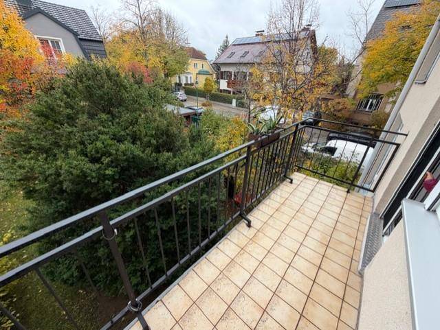 Geräumiger Balkon mit Fliesenboden und Blick ins Grüne, ideal zum Entspannen im Freien.
