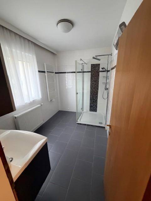 Modernes Badezimmer mit Dusche, Badewanne und Fliesenboden, inklusive Handtuchheizkörper.