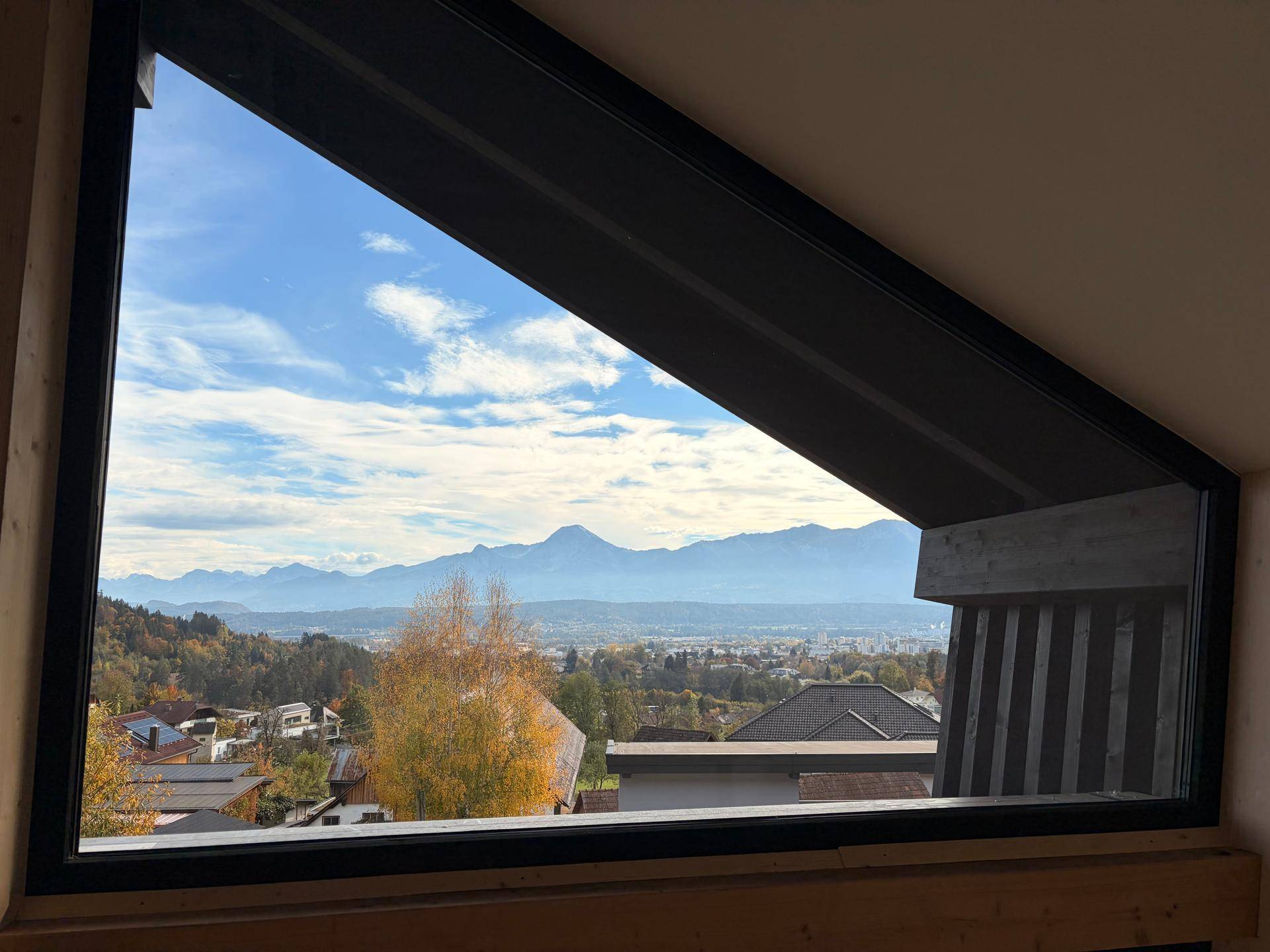 Große Fensterfront mit weitem Blick auf die umliegende Landschaft und die Berge.