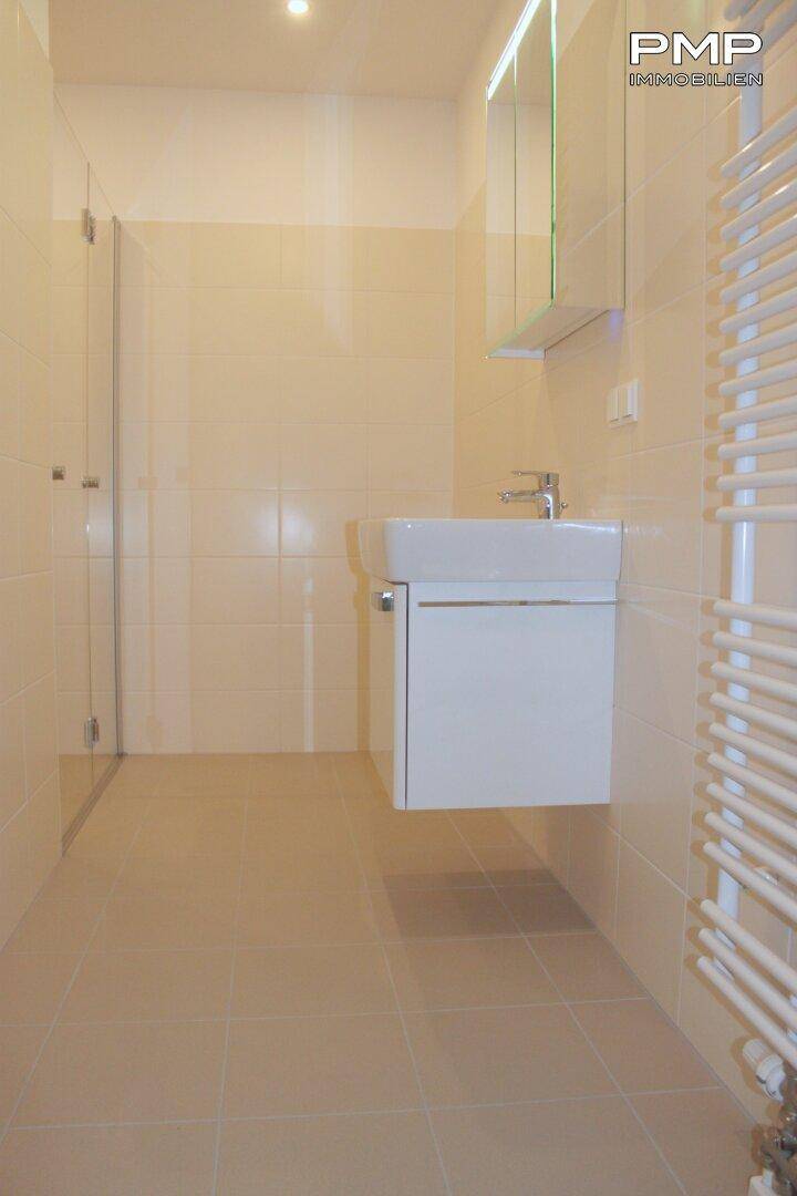 Badezimmer mit bodenebener Dusche, Spiegelschrank und Waschtisch-Unterschrank