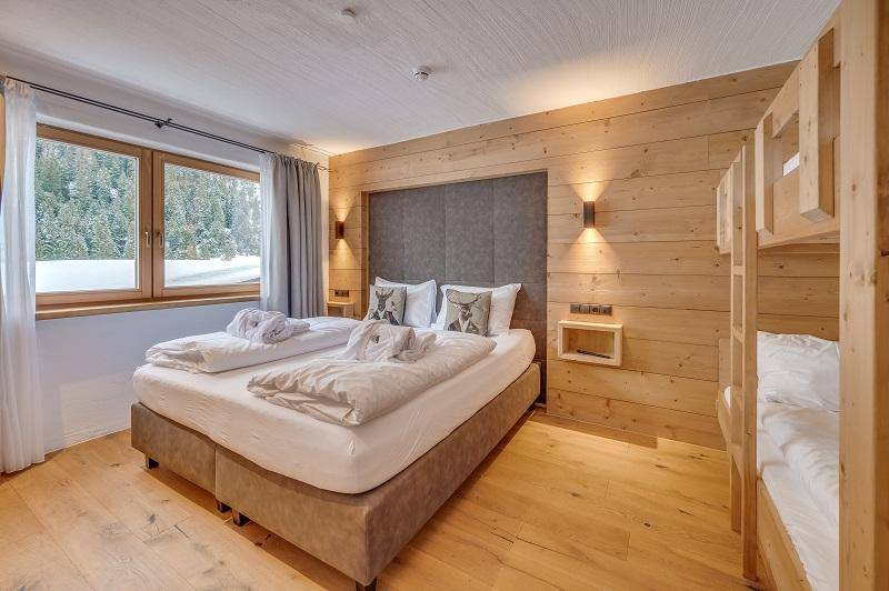 Schlafzimmer mit Doppelbett, zusätzlichem Stockbett und separatem Bad