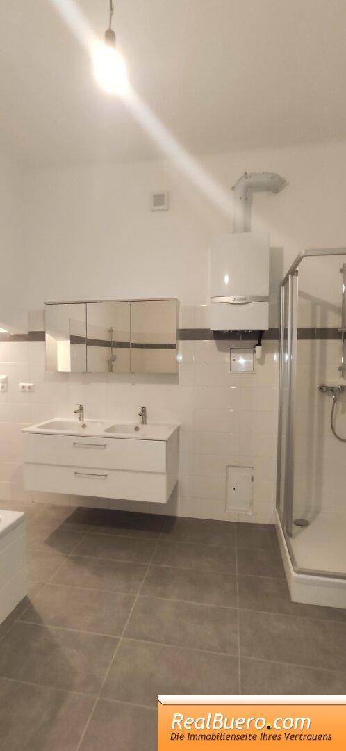 Badezimmer mit Doppelhandwaschbecken, Wanne, Dusche, Waschmaschinenanschluss