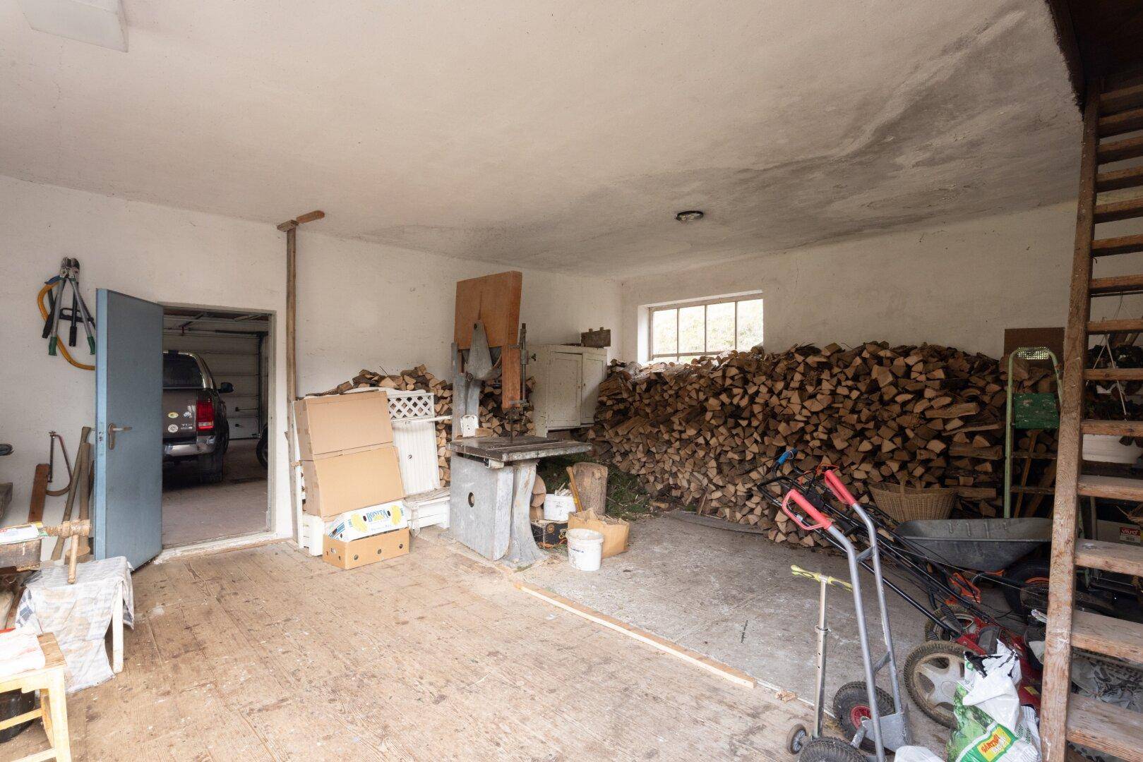 Werkstatt mit Holzlager und Durchgang zur Garage