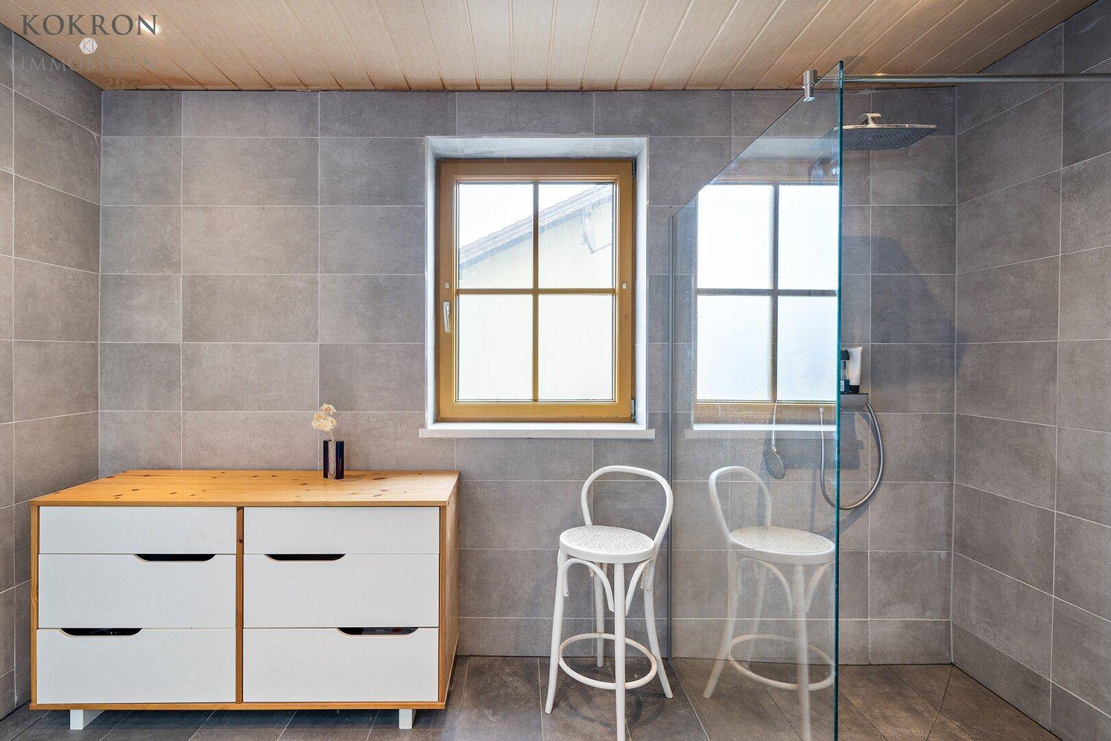 Badezimmer mit Fenster und bodentiefer Dusche im Erdgeschoss