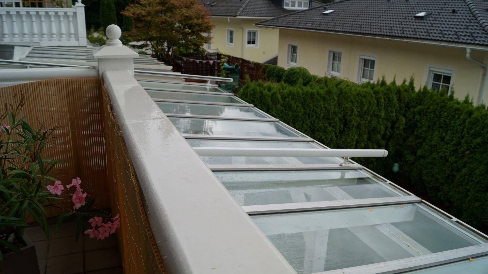 Terrasenüberdachung aus Glas mit Sonnenrollo