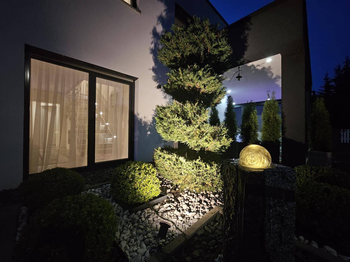 Gartendetail nachts - Brunnen und Beleuchtung